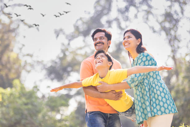 Low angle shot of a parents carrying his son while playing together outdoors
